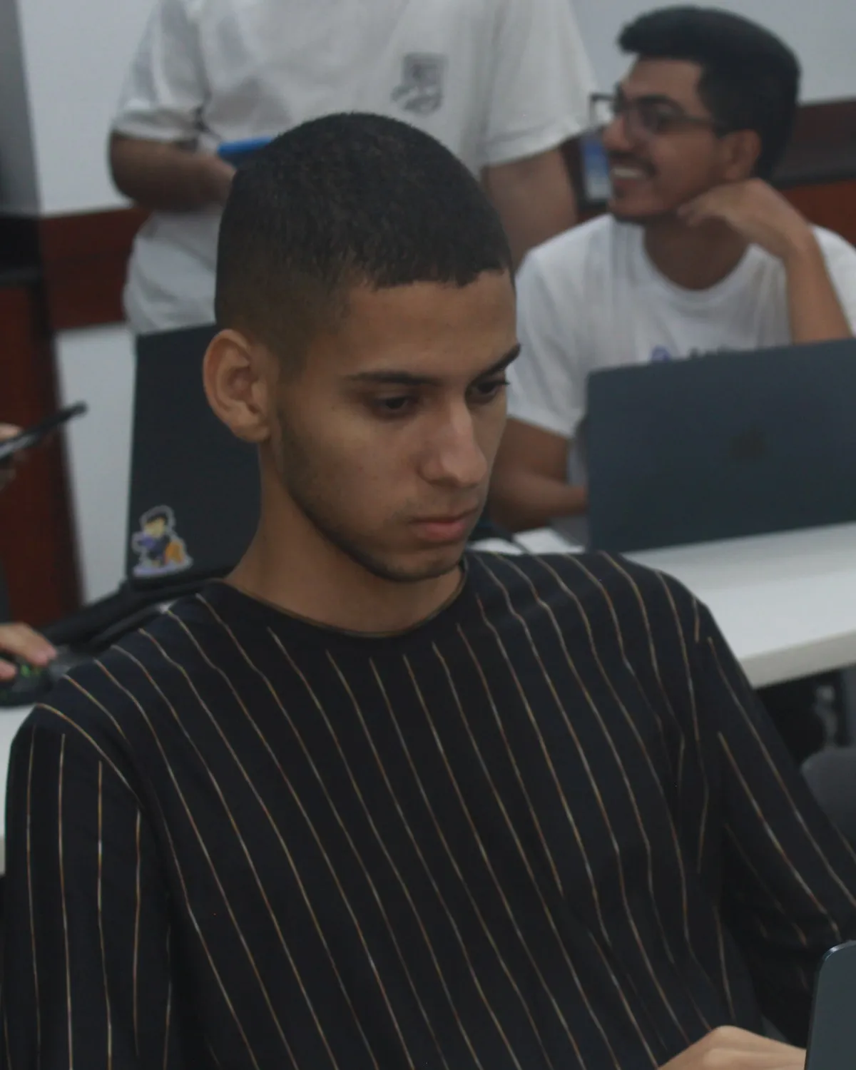 Michael Liendo trabajando en su laptop durante el Hackathon 30X
